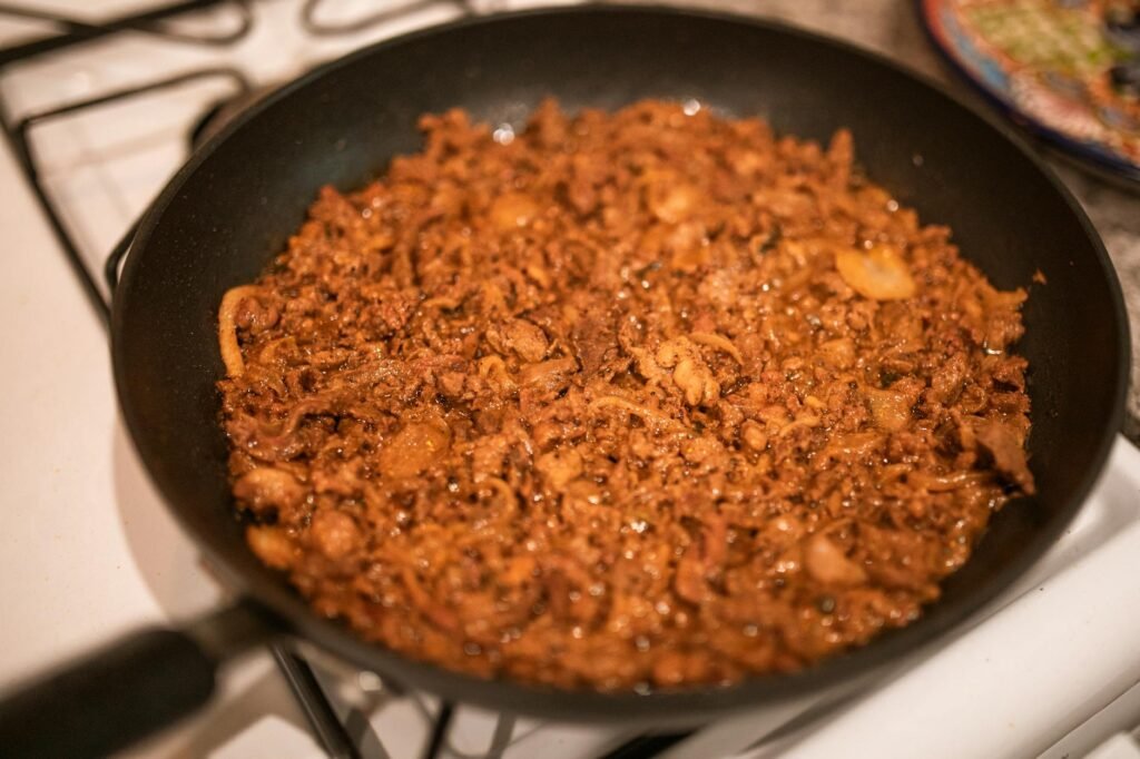 Onions and tomato paste cooking down in a skillet